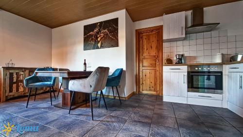 a kitchen with a table and some blue chairs at Ferienwohnung 'Loma', im schönen Veischedetal ! in Olpe