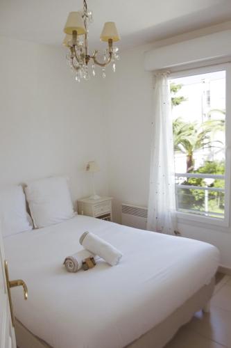 un lit blanc avec un rouleau de papier toilette dessus dans l'établissement Beau 2 pièces au centre de Cannes - Parking, à Cannes