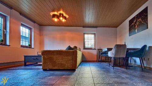 a living room with a couch and a piano at Ferienwohnung 'Loma', im schönen Veischedetal ! in Olpe