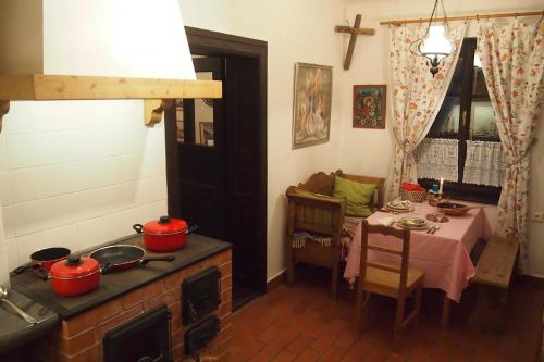 uma cozinha com uma mesa e um fogão com panelas e frigideiras em Orgona Ház em Szécsény