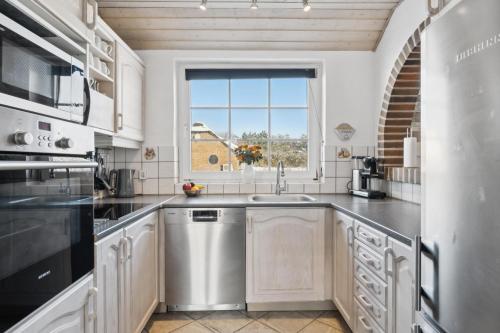 a kitchen with a stainless steel sink and a window at Feriehus 1090 in Ringkøbing