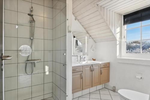 a bathroom with a shower and a sink at Feriehus 1090 in Ringkøbing
