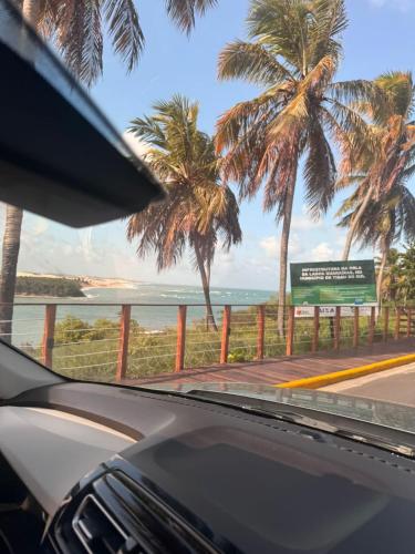 a view from a car window of a road with palm trees at Casa de praia - RIO GRANDE DO NORTE - TIBAU DO SUL in Pipa