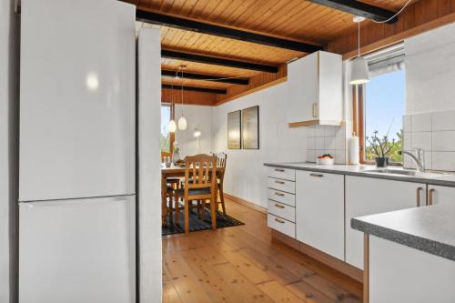 a kitchen with white cabinets and a wooden ceiling at Feriehus 1084 in Ulfborg