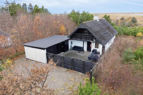 a small white building with a black roof at Feriehus 1084 in Ulfborg