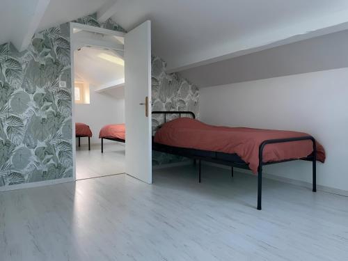 a bedroom with a bed with a red blanket and a mirror at Halte à Saint Leu - Maison 5 personnes in Saint-Leu
