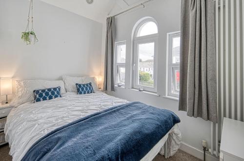 a white bedroom with a bed and two windows at Host & Stay - Sail Loft in Hayle
