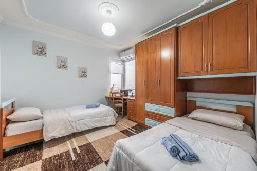 a bedroom with two beds and wooden cabinets at Premium Luxury Beachfront Apartments in Durrës
