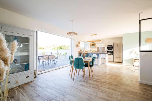 une cuisine et une salle à manger avec une table et des chaises dans l'établissement Villa Nerida 500 M de la Plage, à Andernos-les-Bains