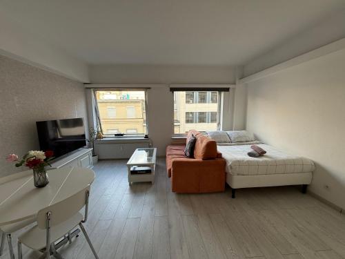 a living room with a bed and a couch at Lovely condo next to European Area in Brussels