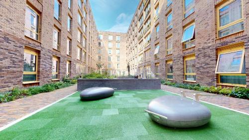 a courtyard with two ottomans in front of buildings at For Students Only iQ Signal Place Nottingham in Nottingham