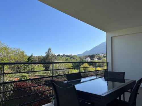 un balcon avec une table et des chaises et une vue dans l'établissement Appartement proche de la plage, à Santa-Lucia-di-Moriani