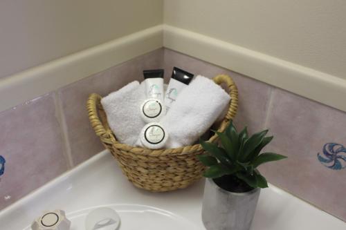 a basket of towels and towels on a bath tub at Motel Northview Mackay in Mackay