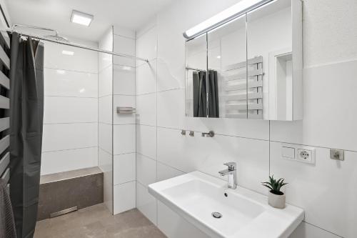 a white bathroom with a sink and a shower at MONTEUR - Unterkunft für bis zu 5 Personen in 63452 Hanau - HU08b in Hanau am Main