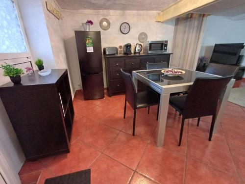 a kitchen with a table and chairs and a refrigerator at Apartamento entero en la montaña in El Pont de Vilomara