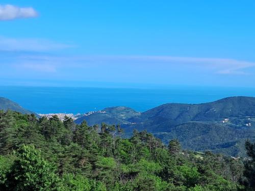 a view of the mountains with the ocean in the background at Villaggio Turistico Tecciù di Cuppi in Magliolo