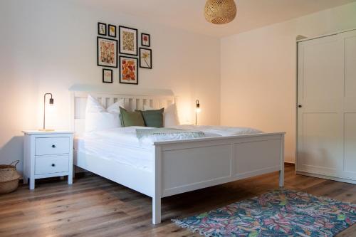 a bedroom with a white bed and a rug at Forellenhof Wald- und Wiesenquartier in Bad Berleburg