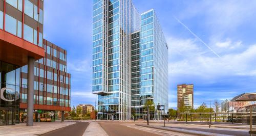 a tall glass building on a city street at PLAZA Premium Almere in Almere