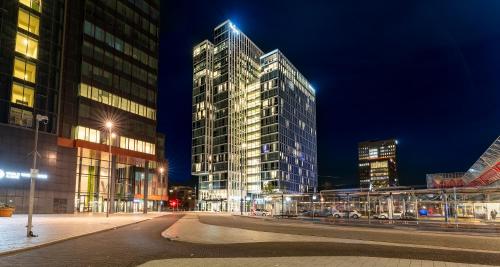 a city street with tall buildings at night at PLAZA Premium Almere in Almere