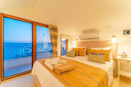 Un dormitorio con una cama grande con una ventana grande. en Villa Olivia, en Kas