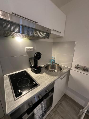 une petite cuisine avec un évier et une cuisinière dans l'établissement # Le 6 # Joli petit studio ! Centre ville au calme, à Mulhouse