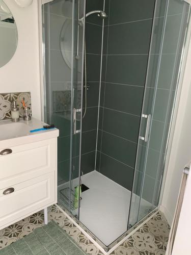 une douche avec une porte vitrée dans une salle de bain dans l'établissement Maison de caractère au coeur de Saint Gilles Croix de Vie, à Saint-Gilles-Croix-de-Vie