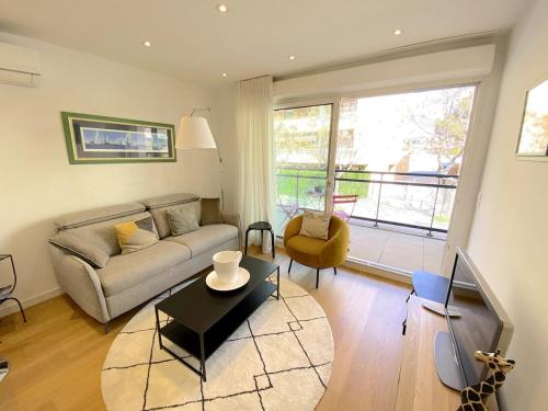 un salon avec un canapé et une table dans l'établissement T2 Neuf centre ville Sanary avec garage, à Sanary-sur-Mer