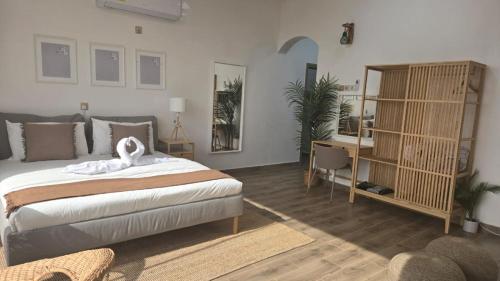a bedroom with a large bed and a desk at Roghan Hospitality Inn in Al Ḩamrāʼ