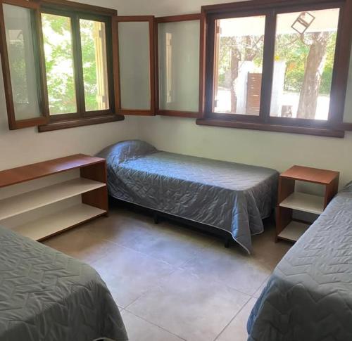 une chambre avec deux lits et deux fenêtres dans l'établissement Chalet Fratelli Rigoni, à Villa Ciudad Parque