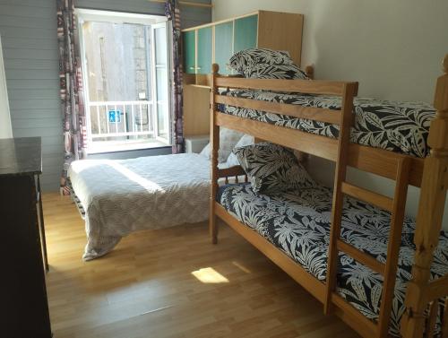 a bedroom with two bunk beds and a window at Maison avec jardin in Saint-Amand-sur-Sèvre