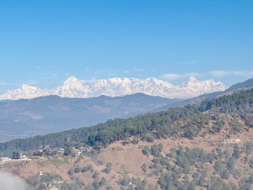 an aerial view of a mountain range with snow covered mountains at Panchwati Farms Homestay in Almora