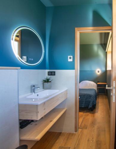 une salle de bain avec un lavabo, un miroir et un lit dans l'établissement Chalet Sportif - Le Cotaret 14 Pax, à Bourg-Saint-Maurice