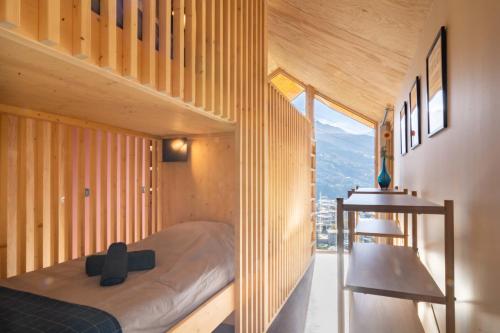 Un dormitorio con una cama y una pared de madera. en Chalet Sportif - Le Cotaret 14 Pax, en Bourg-Saint-Maurice