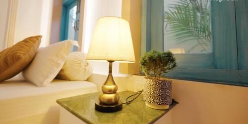 a lamp sitting on a table next to a couch at Bhagvatam by the Ganges in Shivpuri