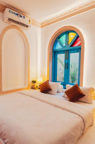 a bedroom with a large bed with a window at Bhagvatam by the Ganges in Shivpuri
