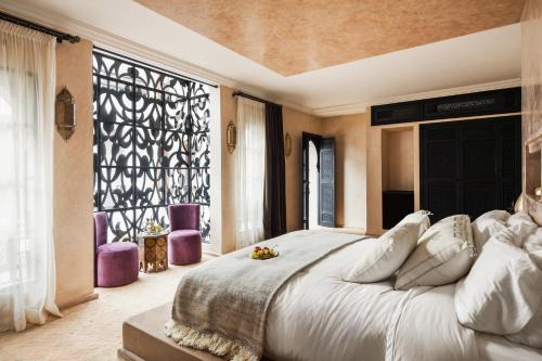 a bedroom with a large bed and a large window at Riad Dar Acsameda & Spa in Marrakech