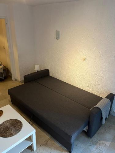 un grand lit dans une chambre avec une table dans l'établissement Coquet studio 10 min de Cannes, au Cannet