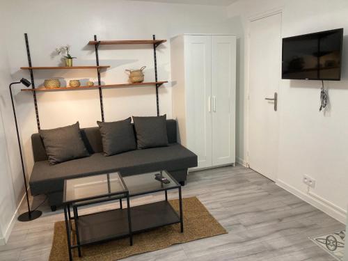 un salon avec un canapé et une table dans l'établissement Studio Gagny - 2min du RER, à Gagny