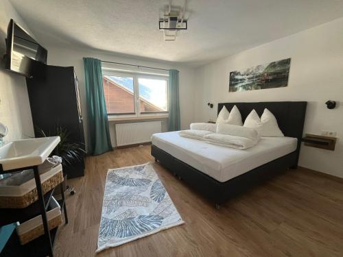 ein Schlafzimmer mit einem Bett mit einem Waschbecken und einem Fenster in der Unterkunft Apart Aurelia in Längenfeld