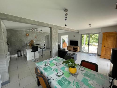 Il comprend une salle à manger et un salon avec une table et une cuisine. dans l'établissement Maison au bord de mer, plage du Portmain, à Pornic