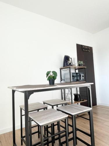 une table avec quatre tabourets et une table avec un four micro-ondes dans l'établissement V5 Très Joli Studio proche Bâle, à Saint-Louis
