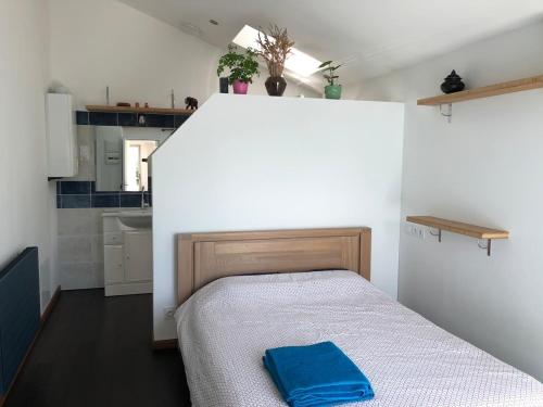 Un dormitorio con una cama con una almohada azul encima. en Maison au bord de mer, plage du Portmain, en Pornic