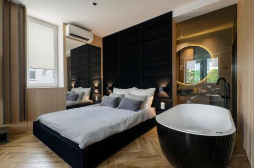 a bedroom with a large bed and a bath tub at LupoApartments z Klimatyzacją do wyboru z Jacuzzi Pole Dance Parking Dostęp na Kod in Łódź