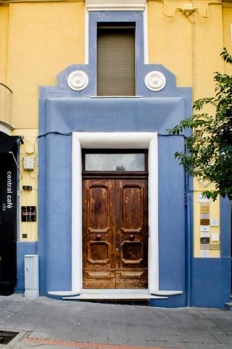 a blue and white building with a wooden door at Amnis rooms in Salerno
