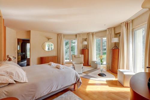 une chambre avec un lit et une chaise dedans dans l'établissement Luxury house or Villa near Paris region, à Anet