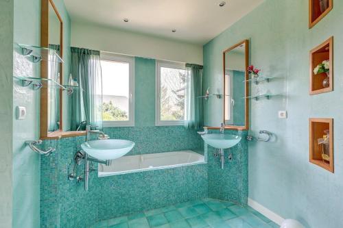 une salle de bain avec deux lavabos et une baignoire dans l'établissement Luxury house or Villa near Paris region, à Anet