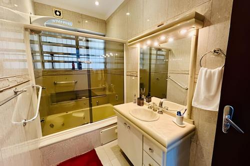 a bathroom with a sink and a large mirror at 0001 - Pousada HG quarto home office, duplo in Vila Gopoúva