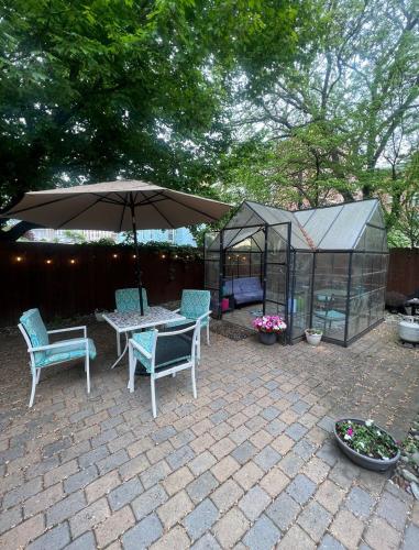 a patio with a table and chairs and an umbrella at Magnolia Stay near New York City in Jersey City