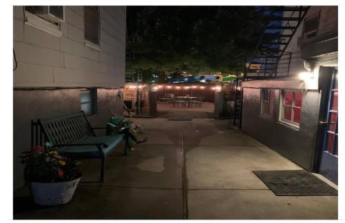 a patio at night with a bench and lights at Magnolia Stay near New York City in Jersey City