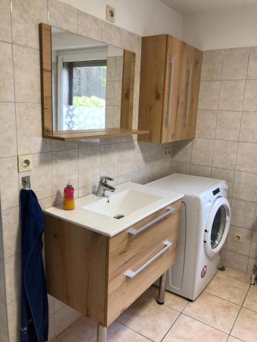 a bathroom with a sink and a washing machine at Zimmer in Kyritz in Kyritz